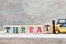 Toy forklift hold block t to complete word threat on wood background