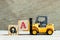 Toy forklift hold block A to complete word QA abbreviation of quality assurance or question and answer on wood background