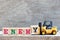 Toy forklift hold block y to complete word enemy on wood background