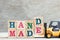 Toy forklift hold letter block D,E to word handmade on wood background