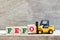 Toy forklift hold letter block O to word FEFO first expired first out on wood background