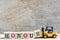 Toy forklift hold letter block r to word honour on wood background