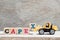 Toy forklift hold letter block x to word capex abbreviation of capital expenditures on wood background