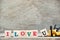 Toy forklift hold letter block u to complete word I love u on wood background & x28;Concept for Valentine& x27;s day