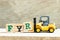 Toy forklift letter block R to complete word FYR abbreviation of for your reference on wood background