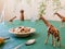 Toy giraffes nibble onplants from the kitchen table as toy animals take over a house