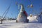 A toy gnome in a cap on the snow, a winter toy gnome sits in a white snowdrift