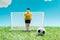 Toy goalkeeper near miniature football gates and ball on blue background with clouds