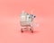 Toy grocery cart with medicines on a pink background. Coronavirus, covid-19 concept. Purchase at a pharmacy