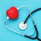 Toy heart and medical stethoscope on a blue background