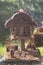 A toy homemade house of a fairy-tale creature made of logs and branches in the park