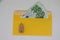 Toy house. banknotes in a yellow envelope. open envelope with banknotes on a light background. envelope with banknotes