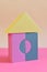 Toy house built from building blocks for children on pink background. Colored cubes in shape of house. house made of blocks