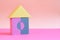 Toy house built from building blocks for children on pink background. Colored cubes in shape of house. house made of blocks