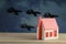 Toy house and formidable silhouettes of military aircraft