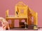 A toy house and a hand depicts a little man. A happy buyer of his own house, his own home, a funny concept.