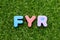 Toy letter in word FYR abbreviation of for your reference on green grass background