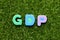 Toy letter in word GDP Abbreviation of good distribution practice or gross domestic product on green grass background