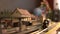 Toy locomotive moving through model train station.