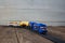 A toy locomotive with wagons on railway on wooden background