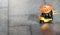 A toy miniature yellow forklift carries a baked cake to a birthday boy. Machine on a gray iron background. Close-up. Free space