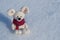 Toy mouse a symbol of the Chinese New Year. In a red knitted scarf. Against the background of white snow. Space for text