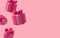 Toy pink gifts with bows fall on pink background