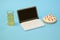 toy plastic laptop with beer and pizza on pastel blue background