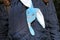 A toy rabbit made of plush sits in a girl\'s bosom and looks out of a blue jacket. Rabbit - a symbol of 2023 year