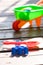 Toy sand pails and shovels over on wooden terrace on sunny day