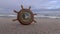 Toy ship wheel clock on the beach