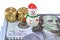 A toy snowman stands near two golden bones on a banknote with a portrait of Franklin and welcomes you / isolated on white.