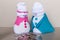 Toy snowmen couple look at pile of coins