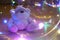 A toy teddy bear surrounded by colored lights. Abstract fairytale magic background