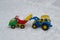 A toy tractor loads snow into a toy truck