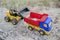 A toy tractor loads a toy dump truc