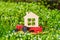 Toy Tractor with a Tiny Flat House Model on a Flowerbed