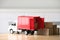 Toy truck and cardboard boxes on table against blurred background. Courier service