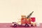 Toy truck carries gifts and a Christmas tree. Photo in vintage style