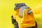 The toy typewriter is a concrete mixer and screwdriver that twists the cog on a yellow background. Photos for a toy store and