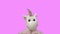 Toy unicorn dancing against pink
