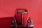 Toy Volkswagen Beetle on a red background, close-up, illustrative editorial