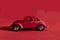 Toy Volkswagen Beetle on a red background, close-up, illustrative editorial. Date and location: Kiev, Ukraine September 2020