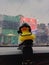 toy yellow duck wearing helmet and necklace against building background