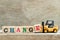 Toy yellow forklift hold block letter e to complete word change