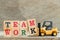 Toy yellow forklift hold block letter m and k to complete word