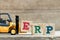 Toy yellow forklift hold letter block E to complete word ERP Abbreviation of Enterprise Resource Planning