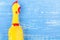 Toy yellow shrilling chicken on blue wooden background