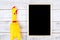 Toy yellow shrilling chicken on white wooden background with blackboard and copy space .Template mock up for adding your design