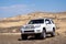 Toyota 4runner SUV in desert canyon with blue sky. 4wd SUV car road canyon desert. Outdoor landscape. Travel in Kazakhstan concep